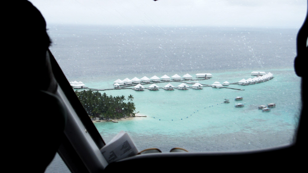 Coming in to land at Athuruga in a rainshower - view over the pilot's shoulder showing the new Water Village to the west of the island. (108k)