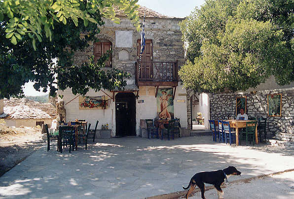 Linda enjoying a beer in the shade at the taverna in the main square at Kastro.  The church is behind her.   (61k)