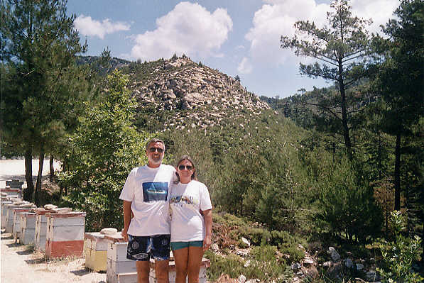 The lake is just downhill to the right as we pose in front of a row of beehives.  Honey is a very important crop on Thassos - it's sold everywhere.  (59k)