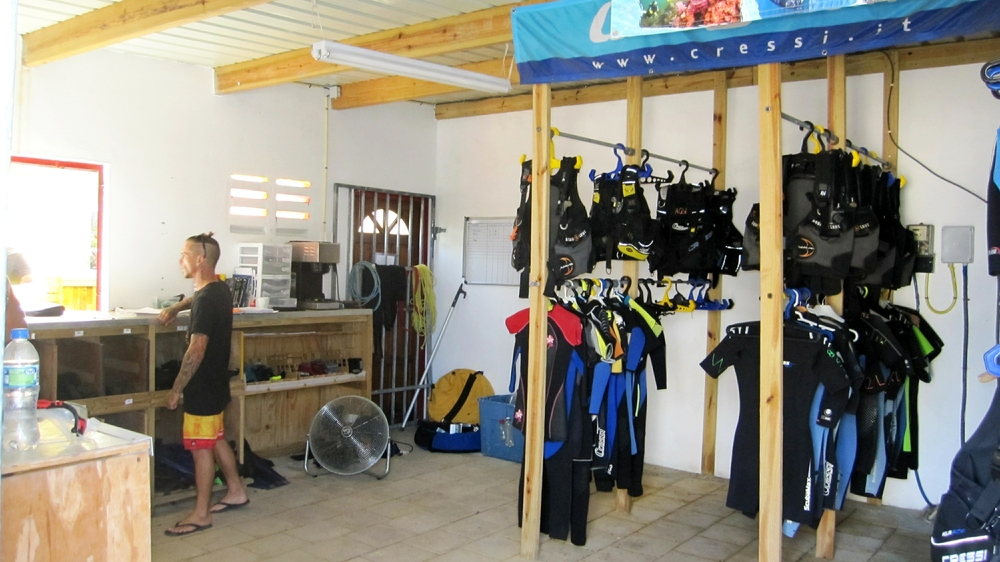 Inside the equipment storage room. Rien chats to someone at the equipment counter.