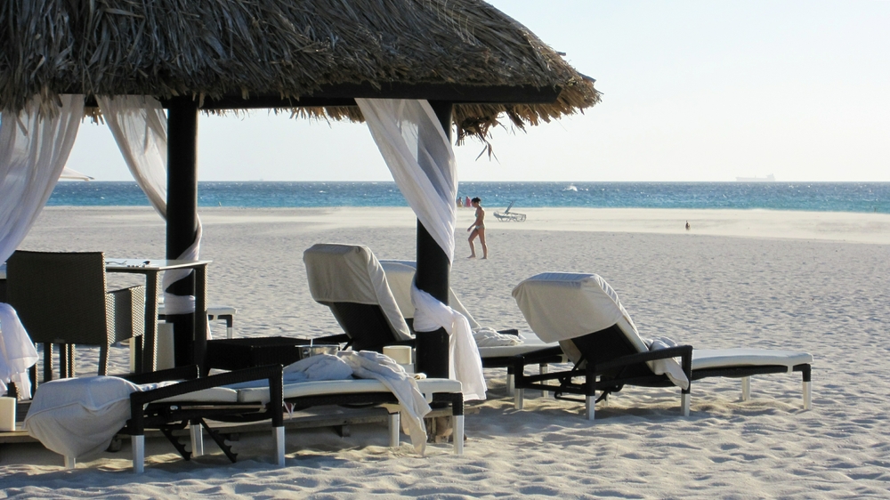 The beach stretches for a couple of hundred metres beyond the sun umbrellas of Bucuti down to the shoreline. Here you can see 
					where a sandstorm is whipping across the beach, driven by the constant trade winds.