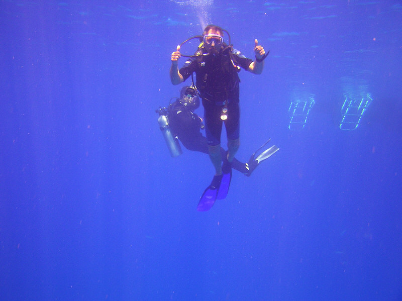 My Yorkshire buddy Roy signals 'I'm surfacing' next to the boat ladders after the dive.   (88k)