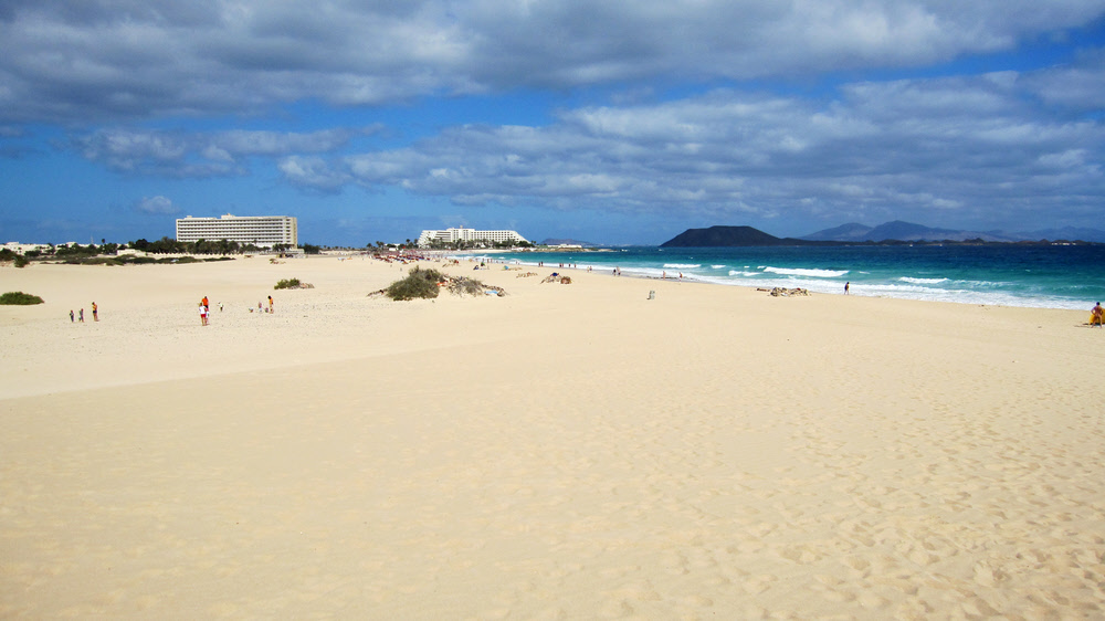 The hotels, Isla de Lobos and Lanzarote from the dunes. (131k)