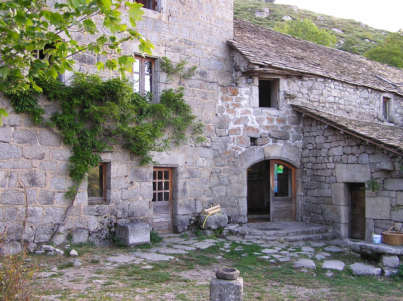 The terrace in front of the old stone farmhouse of le Merlet. The double door leads in to the kitchen and dining room.  (236k)