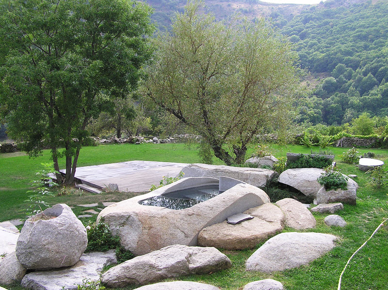 The hot tub set in a ground-out solid granite boulder in the garden at le Mas Nouveau.  (248k)