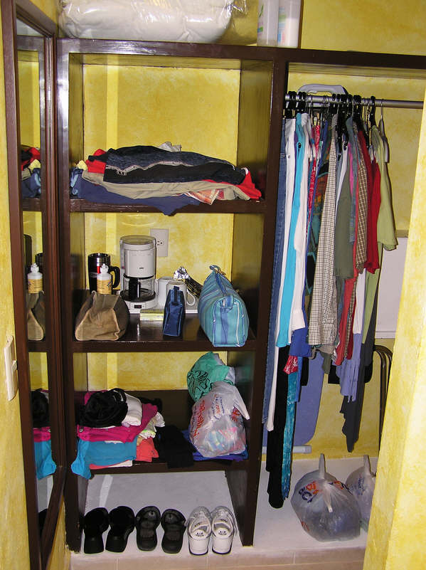 Clothes storage area, including coffee-making equipment, iron and ironing board.  (88k)