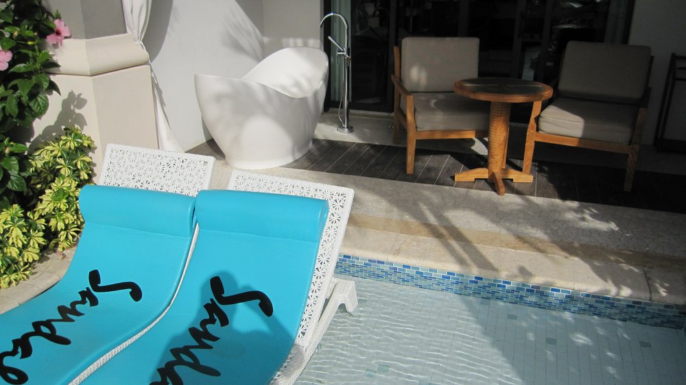 The veranda, showing the bath (and the huge curtains to preserve your modesty therein), seating, and sunbeds in the pool shallows.