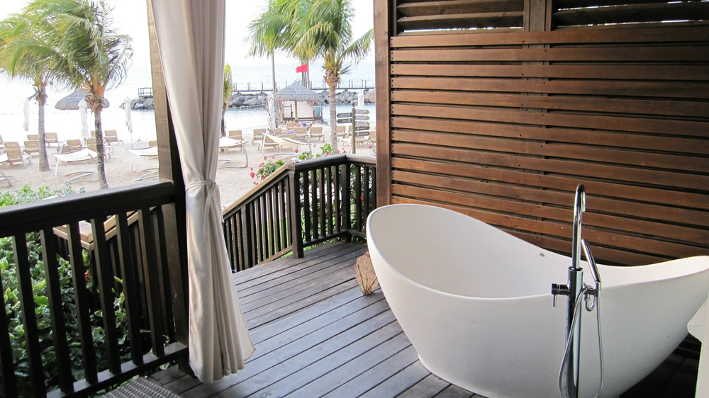 The decking area on our patio. We share the steps down to the beach with next door. The unused tub on the right.