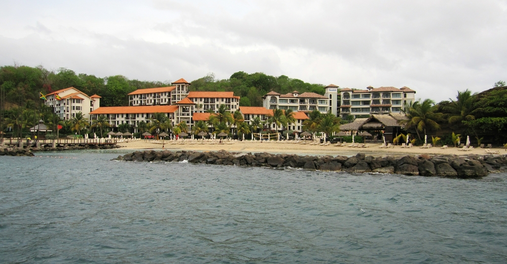 Sandals from the sea. From left to right: the Pink Gin wing with the red roof, the taller Italian building with a browner roof behind it, and
        the thatched roof of Neptune's restaurant. 