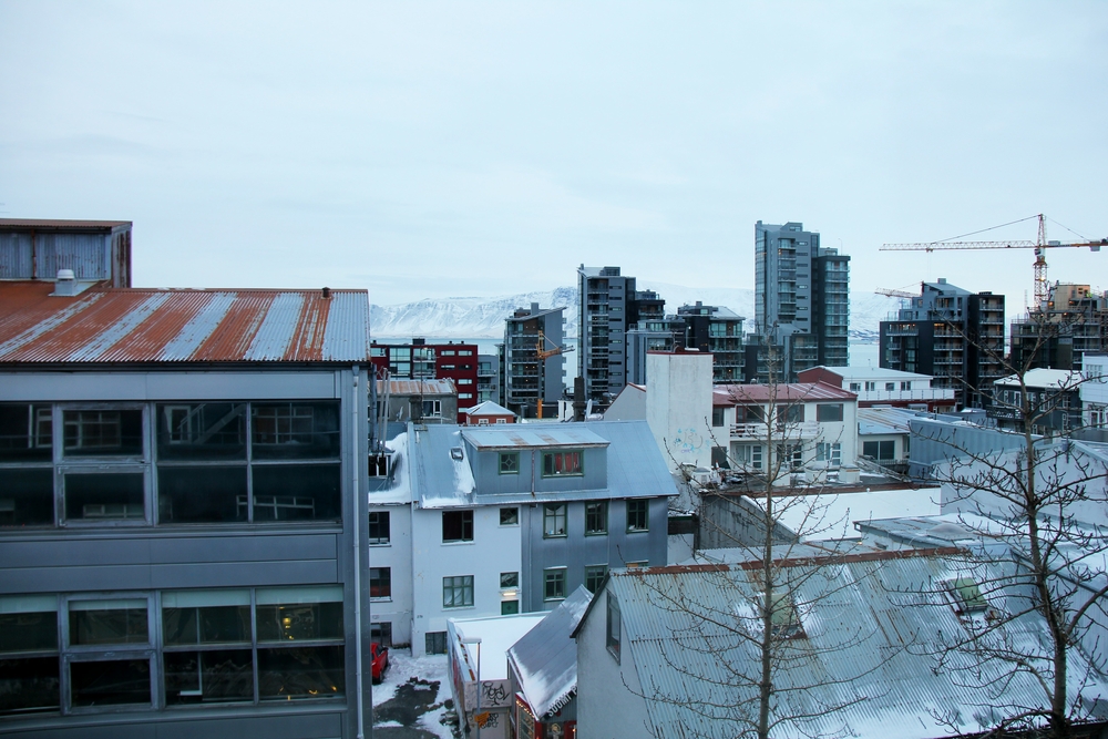 The view from our bedroom window at Hotel Fron, looking northwards across rusty corrugated iron roofs to the sea and the snow-covered mountains.