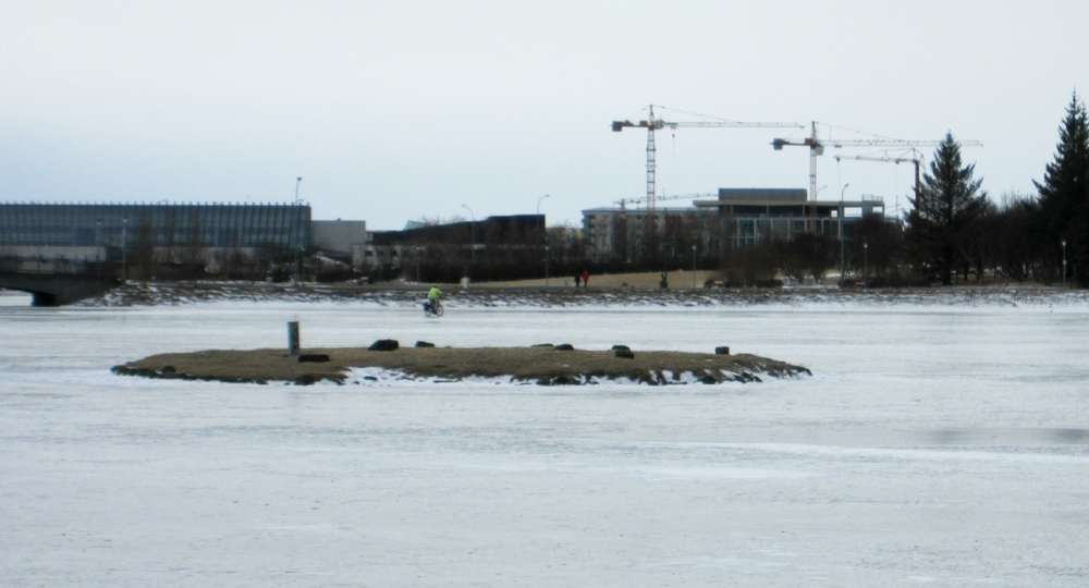 Meanwhile, in the distance, a cyclist rides across the frozen lake.