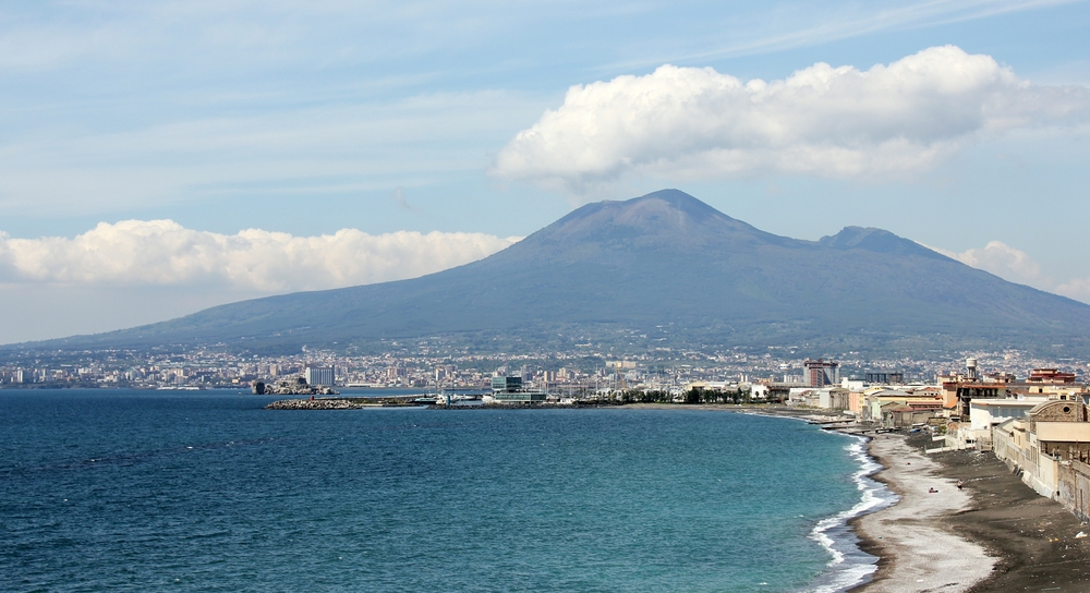 Looking north from our third-floor hotel room balcony. The volcanic cone of Vesuvius broods ominously over the whole area. Note the grubby-looking, but
        nevertheless clean, dark volcanic sand.