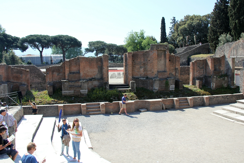 The wooden stage occupied the area beyond the low brick wall with the steps. The horseshoe-shaped area in front of the stage was called the orchestra.