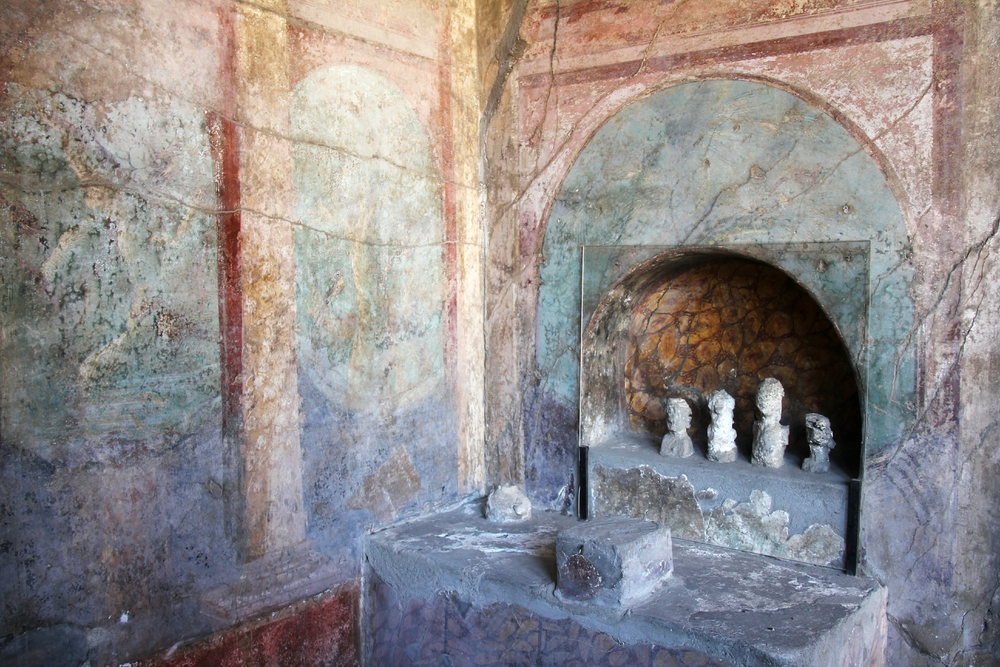 This shrine in one corner of the atrium is called a Lararium, and is sacred to the Lares, or household gods. These are plaster casts of the original
        wooden or wax figures.