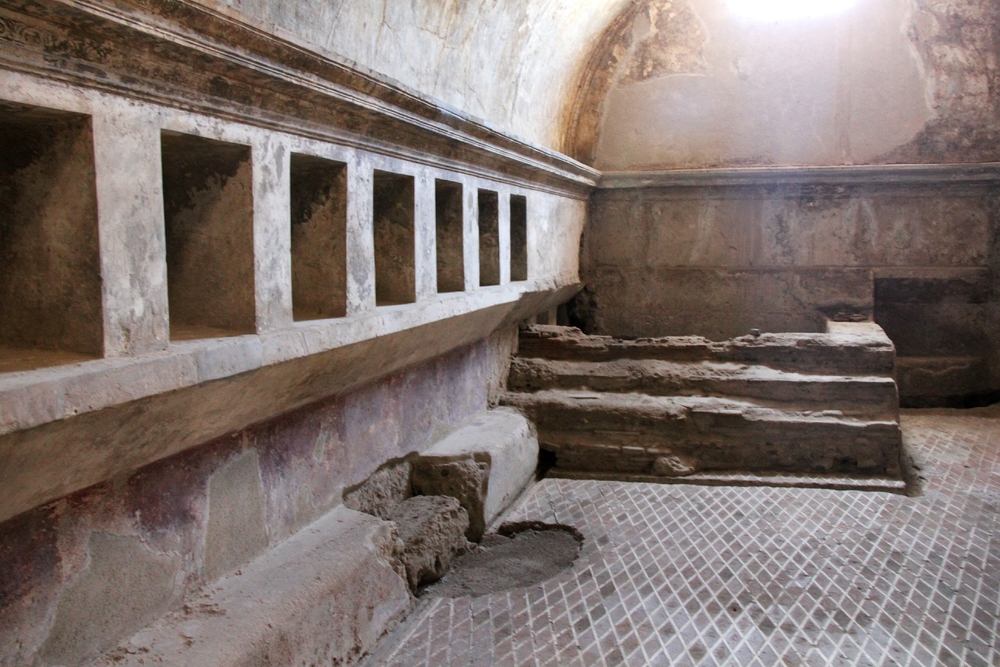Inside the women's bath house. This is the mosaic-floored changing room - the niches along the wall are to store your clothes in. There's a cold plunge
        pool at the back.