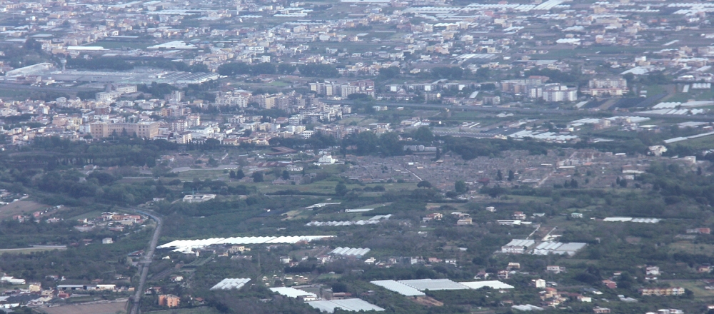 The excavations at Pompeii from the crater rim. You can just make out the grey stone buildings of the town to the right of centre.