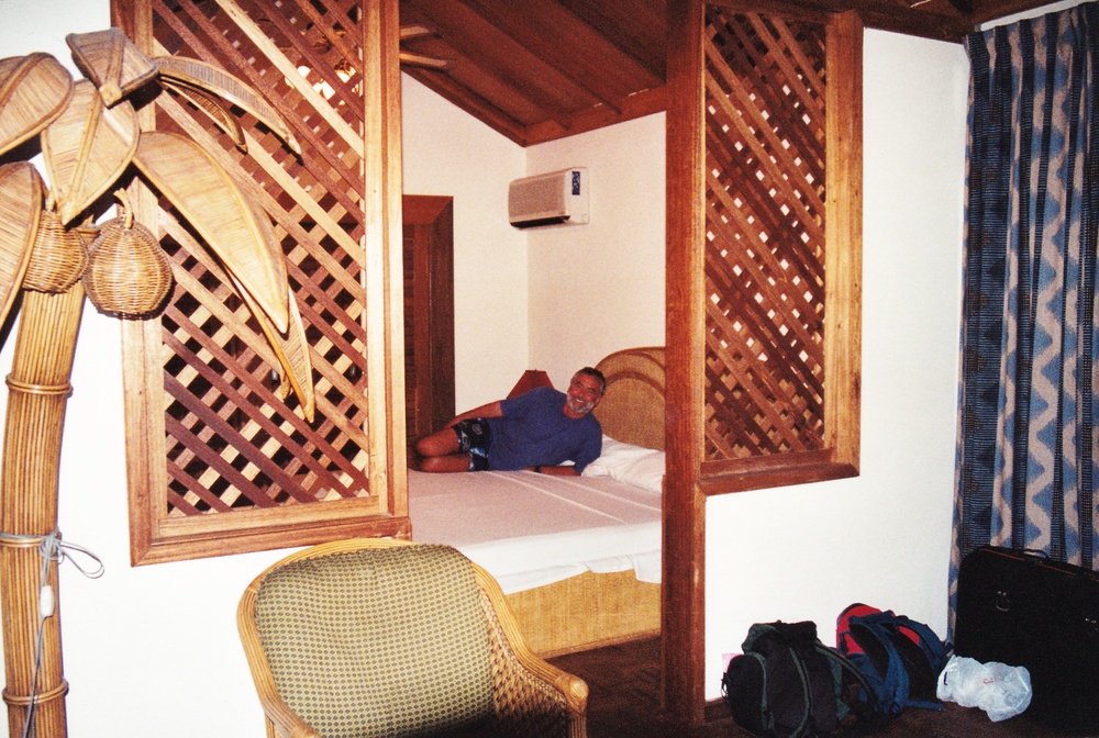 John reclining seductively on the bed. Picture taken from the lounge area through the door into the bedroom.