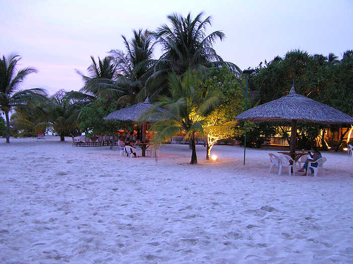 On the beach in front of the bar and restaurant at sunset. (61k)