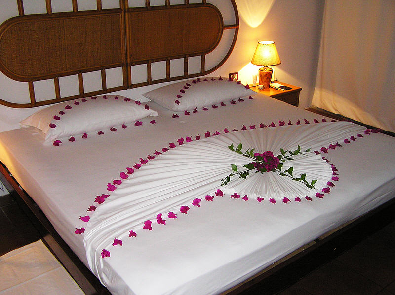 Beds always get decorated with bougainvillea on your last night. (97k)