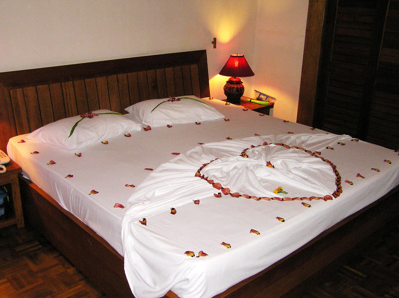 At Reethi Beach, our room boy decorates the bed with flower petals.  (74k)