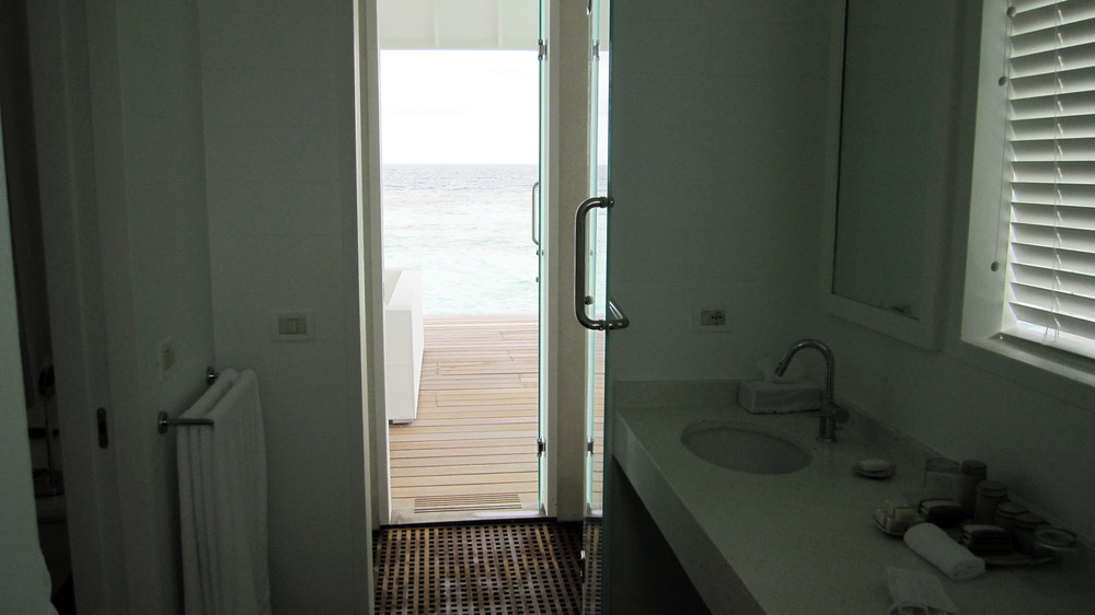 Part of the bathroom, showing one of the washbasins, the door into the shower cubicle, and the door from there out onto the deck.  (108k)