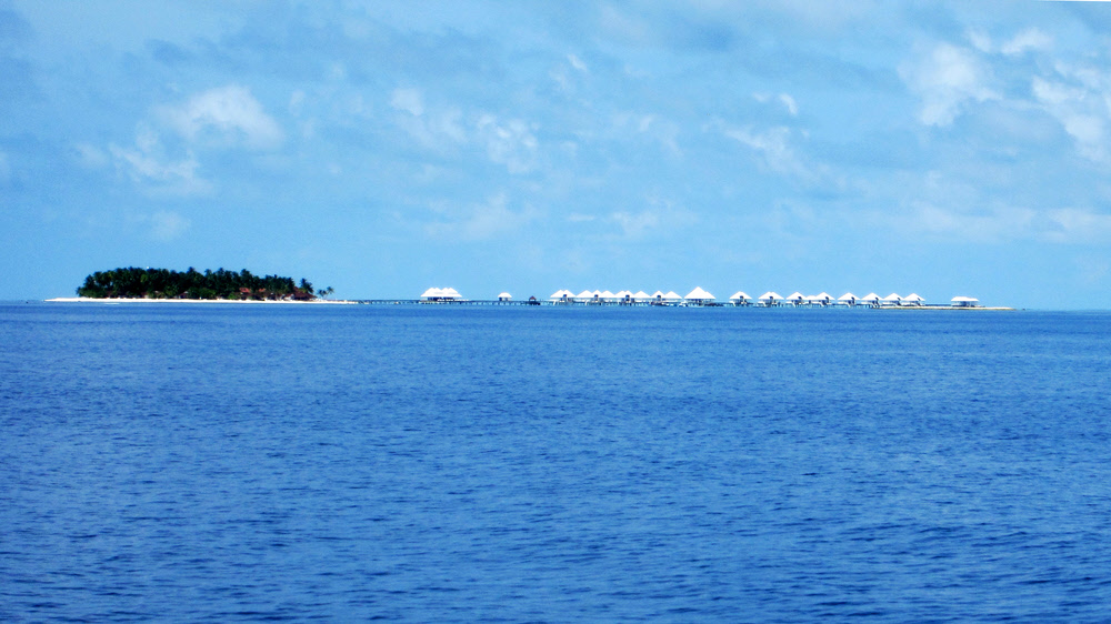 This is sister island Thudufushi from the dive boat, showing the newly-built water village - same design as Athuruga's.   (189k)