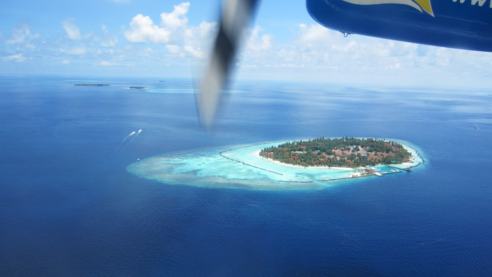 Passing over resort islands soon after take-off from the seaplane terminal at Male airport.  (107k)