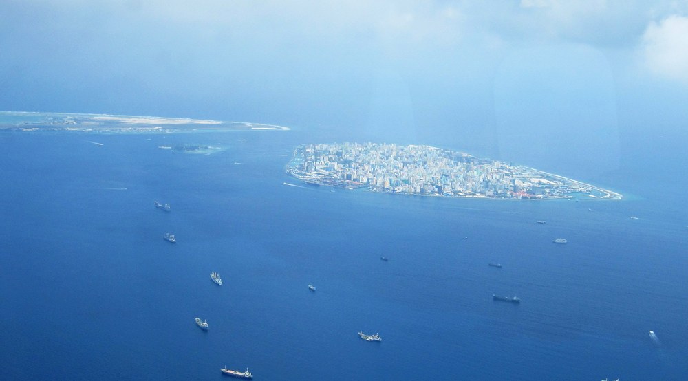 Male, the crowded capital island, with one end of the international airport's runway on Hulule island in the background.