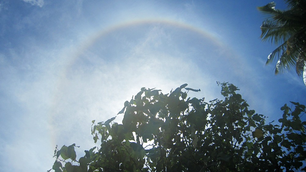 An unusual rainbow around the sun above the island one day, caused by tiny ice particles in high cirrus clouds.