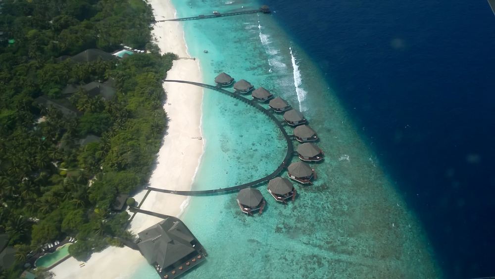 A few seconds later - we've passed over the eastern end of the island. From top to bottom: the north jetty, the water villas, and the water villa restaurant.