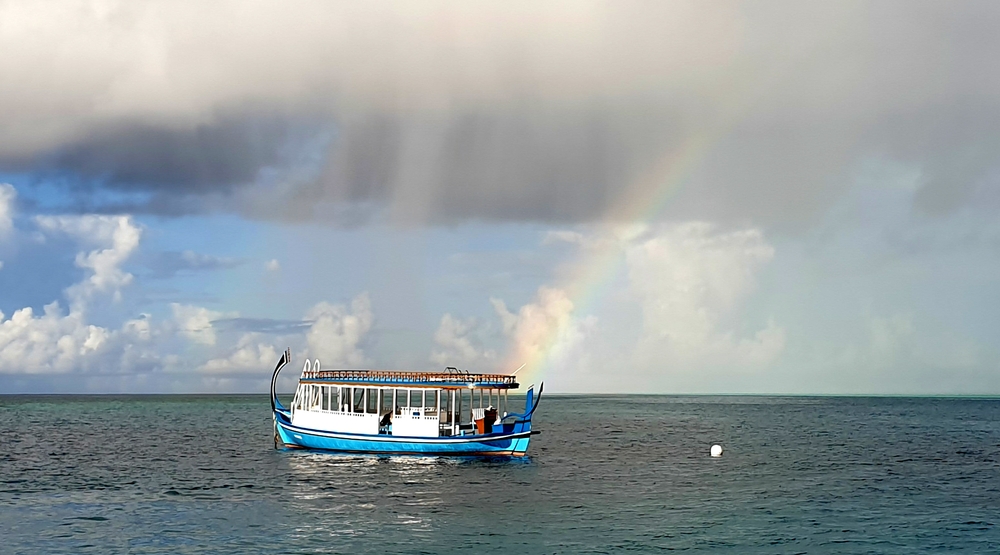 A tropical shower produces a rainbow.