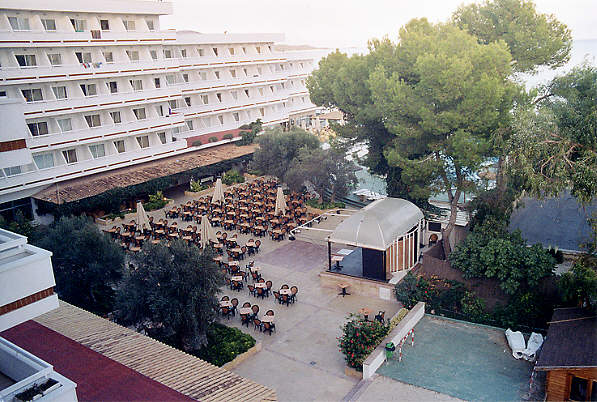 View from our balcony down onto the entertainment area. The pool is behind the trees, and the beach beyond that. (69k)