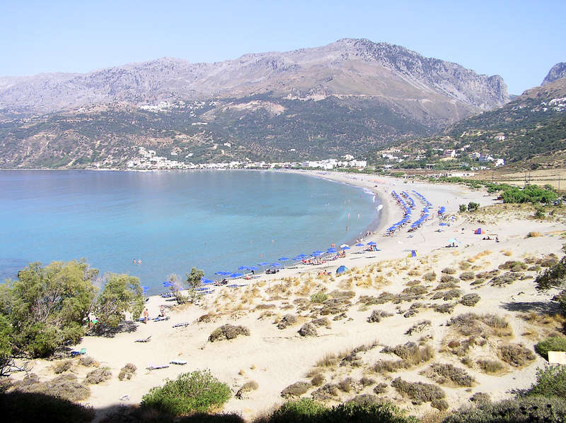 Plakias beach looking back towards the village, with Selia village above and behind it.  (97k)