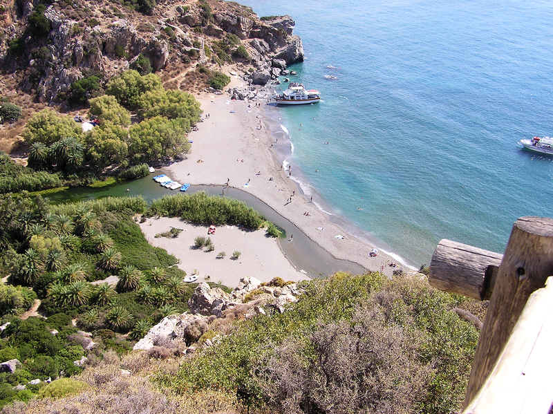Preveli beach with the river flowing down from among the palm trees into the sea.  (99k)