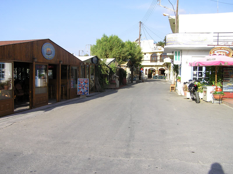 The main road in the centre of Plakias early in the morning.�Some of the harbour-side tavernas on the left. (97k)
