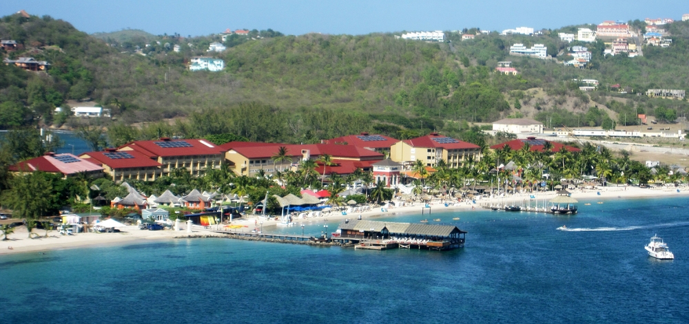 The view of the red-roofed buildings of Sandals, Grande St Lucian, from Fort Rodney. Our room was in the Cap Estate building, the tallest one,
        third from the left.