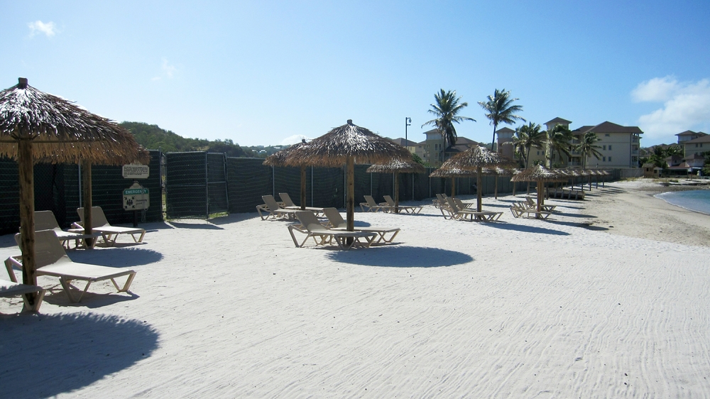 Sandals have put safety-fencing around the empty plot next door, and taken the opportunity to put up sun-shades along the beach.